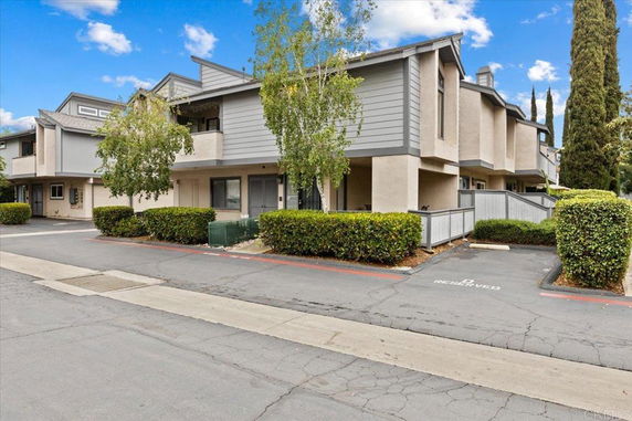 Front view of a two-story modern townhouse with attached parking area.