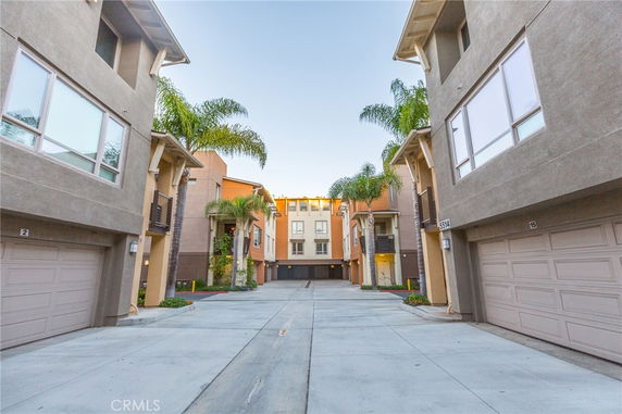 Front view of a row of multi-story townhouses with garages.