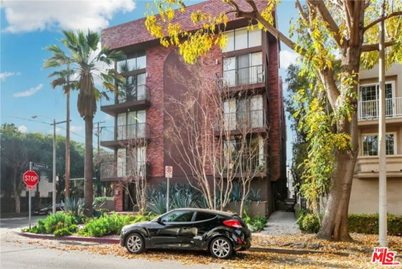 Front view of a multi-story apartment building with balconies.