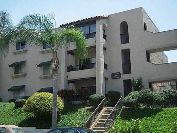 Front view of a multi-story building with balconies and stairs.