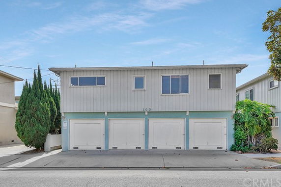 Front view of a two-story building with garages on the ground floor.