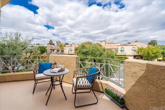 Balcony view overlooking residential area with houses and trees.