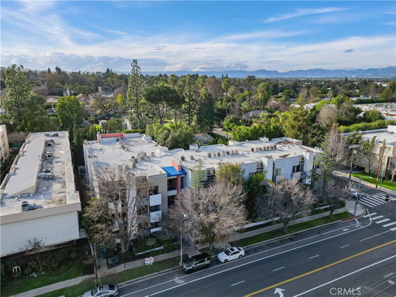 Aerial view of a building complex with surrounding residential and green areas.