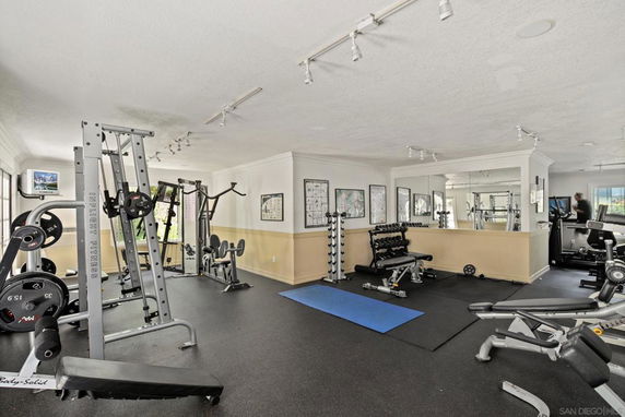 Indoor gym area with various exercise equipment and weights.
