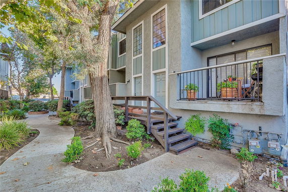 Front view of a multi-story townhouse with a porch and steps.