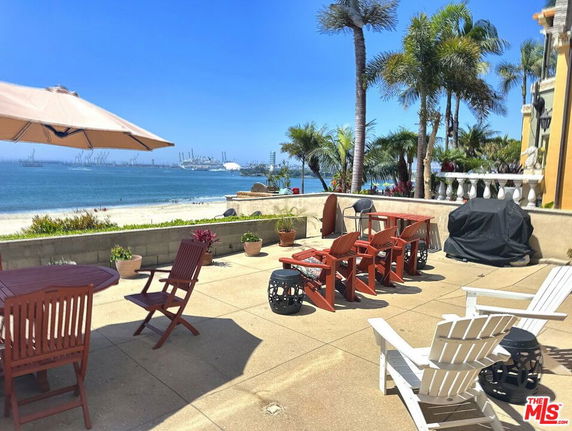 Panoramic view from a patio overlooking a beach and ocean.
