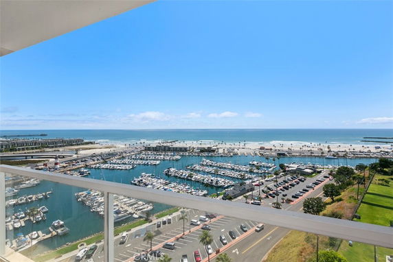 Panoramic view of a marina with boats and the ocean in the background from a high vantage point.