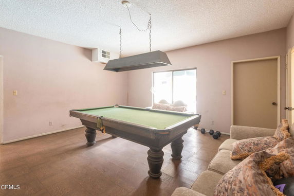 Room with a pool table and a couch