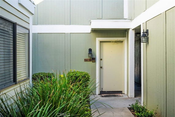 Entrance of a residential building with a single door and exterior wall lights.