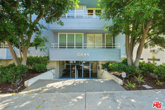Front view of a multi-story residential building with a modern facade and entrance steps.