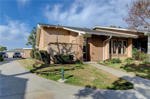 Front view of a single-story house with a sloped roof and driveway.