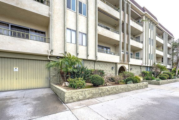 Front view of a multi-story apartment building with balconies.