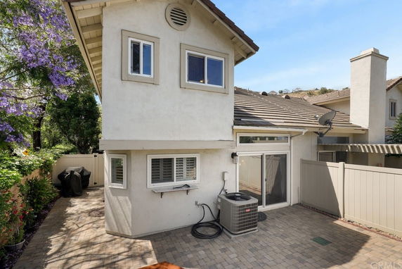 Side view of a two-story house with an air conditioning unit outside.