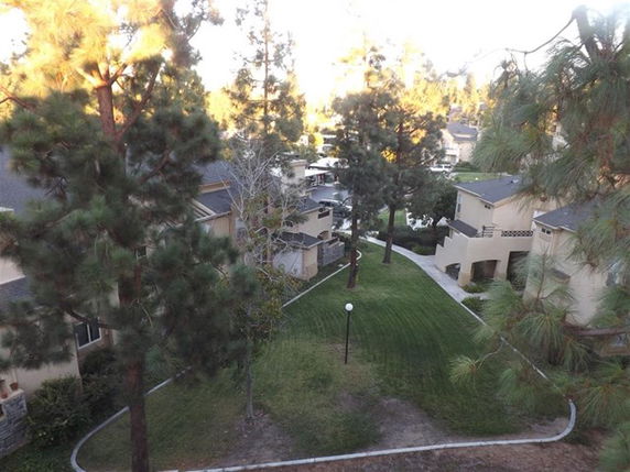 Aerial view of residential buildings surrounded by trees and green lawns.