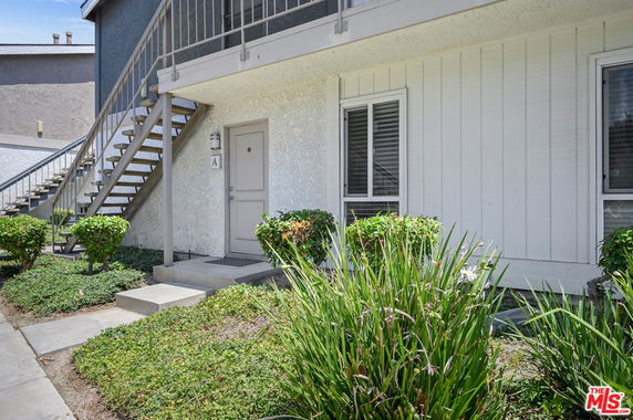 Front view of a building with an external staircase leading to the upper floor.