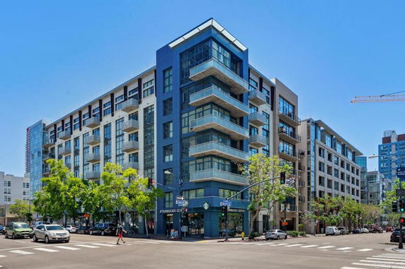 Front view of a multi-story apartment building with balconies and large windows.