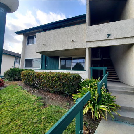 Front view of a two-story building with stairway access.
