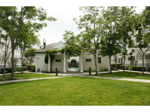 Front view of a small building with a central open entrance and trees surrounding it.