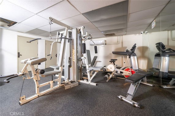 Indoor gym area with exercise equipment including weight machines and stationary bikes.