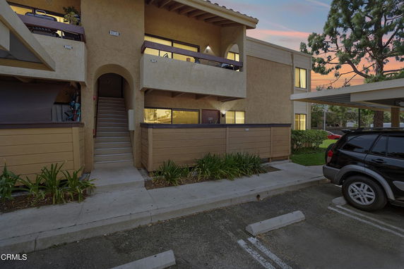 Front view of a two-story residential building with parking area.