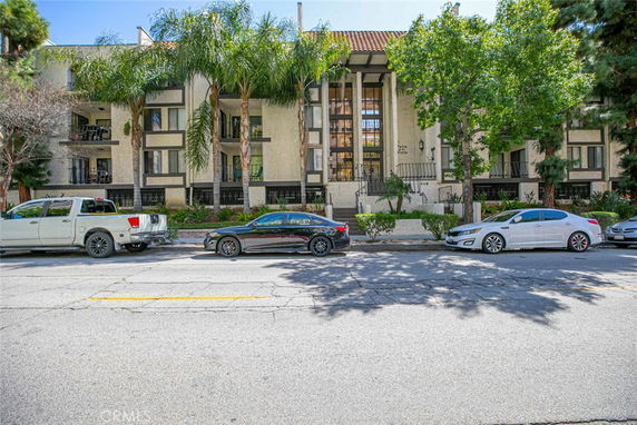 Front view of a multi-story apartment building with balconies.