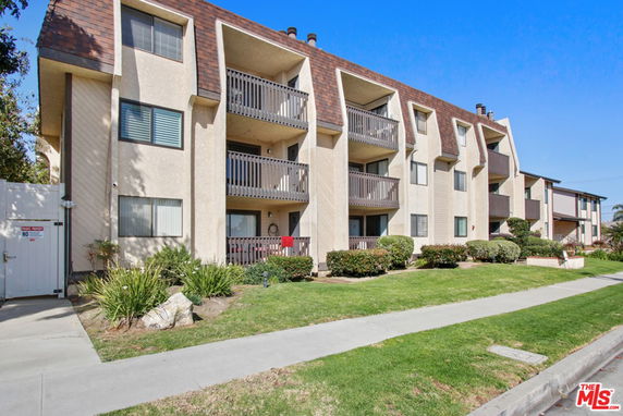 Front view of a multi-story apartment building with balconies.