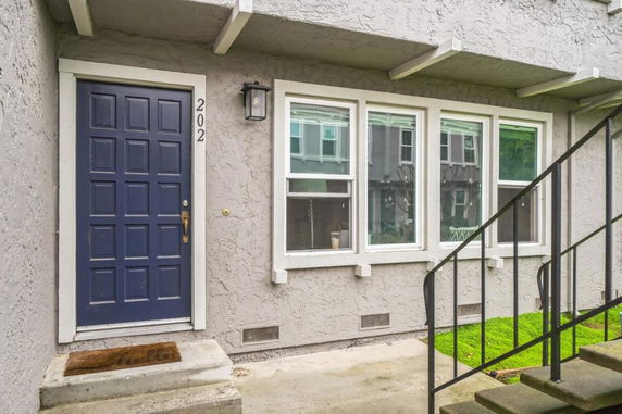 Front view of a house with a dark blue door and several windows.