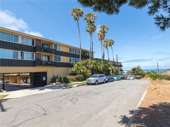 Front view of a multi-story apartment building with balconies.