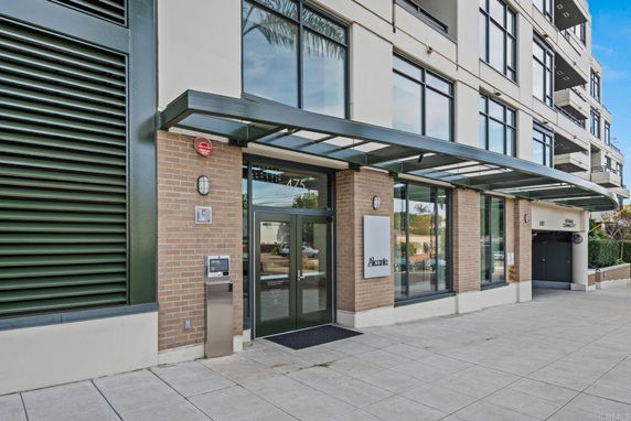 Front view of a multi-story building with glass windows and a covered entrance.