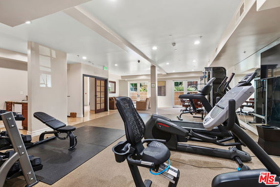 Indoor gym area with exercise equipment and mirrors.