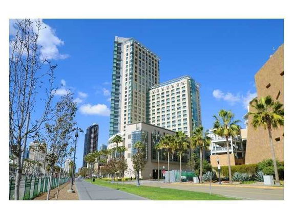 Front view of a high-rise building with glass windows and adjacent structures.
