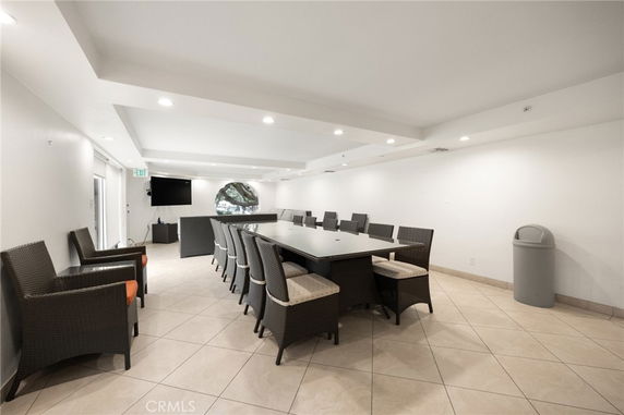 Interior view of a room with a long table surrounded by chairs, suitable for meetings or gatherings.