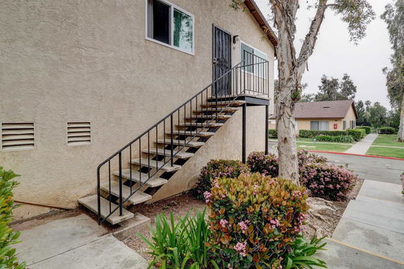 Side view of an exterior staircase leading to a second-floor entrance of a building.