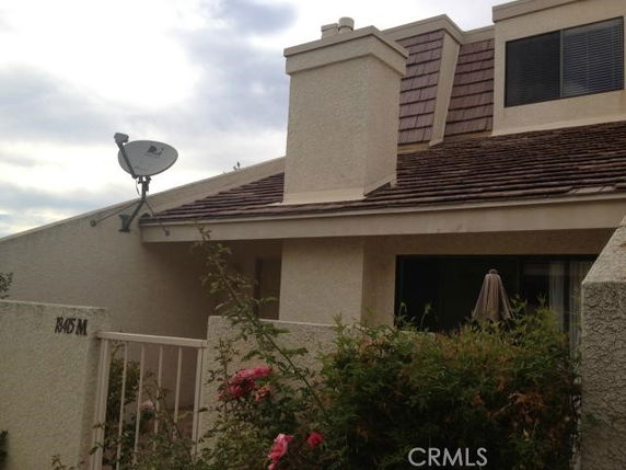 Front view of a house with a chimney and satellite dish.