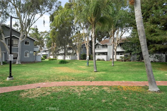 Front view of multi-story residential buildings with a lawn and trees.