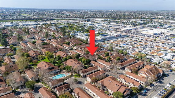 Aerial view of a residential area with multiple buildings and a pool.