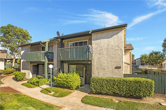 Front view of a two-story residential building with two balconies.