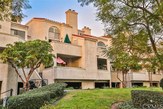 Front view of a multi-story residential building with balconies and chimneys.