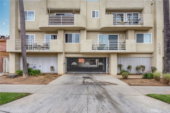 Front view of a multi-story building with balconies and a garage entrance.