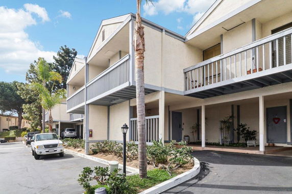 Front view of a two-story residential building with balconies and covered parking.