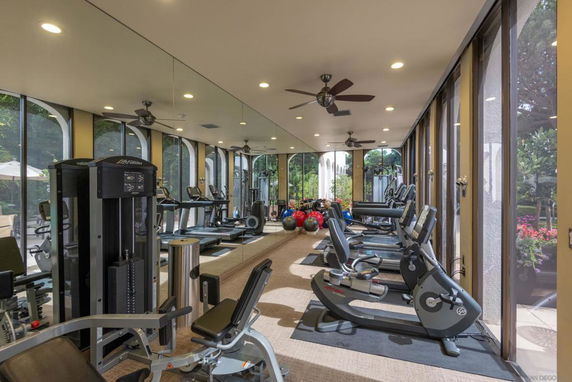 Gym area with exercise equipment and large windows.
