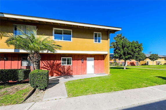 Front view of a two-story house with yellow and red exterior.