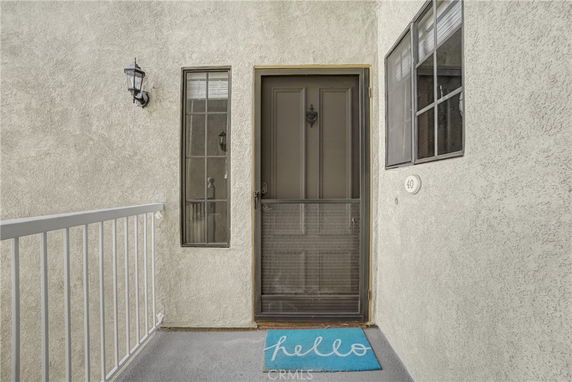 Front view of a house entrance with a door, windows, and a light fixture.