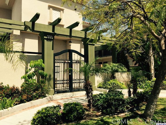 Front view of a building with a decorative gate and green columns.