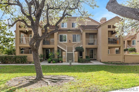 Front view of an apartment building with multiple balconies and stairs.