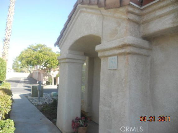 Front view of a house with an arched entrance and stucco finish.