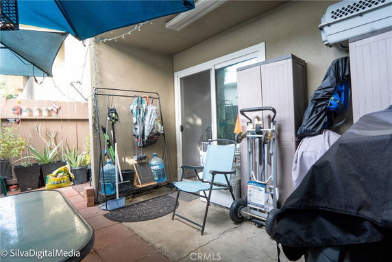Outdoor patio area with chairs, storage units, and gardening tools.