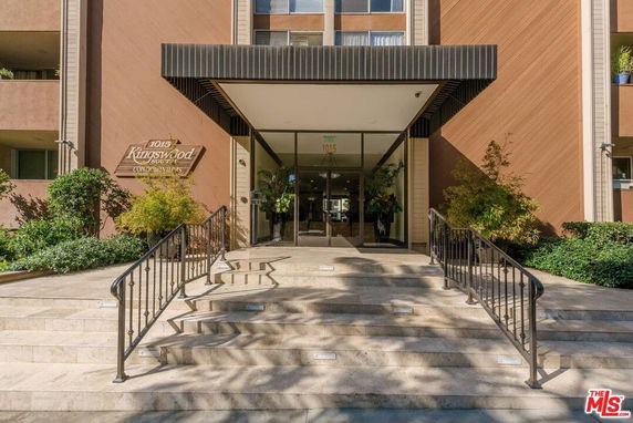 Front view of a condominium entrance with stairs leading to the door.
