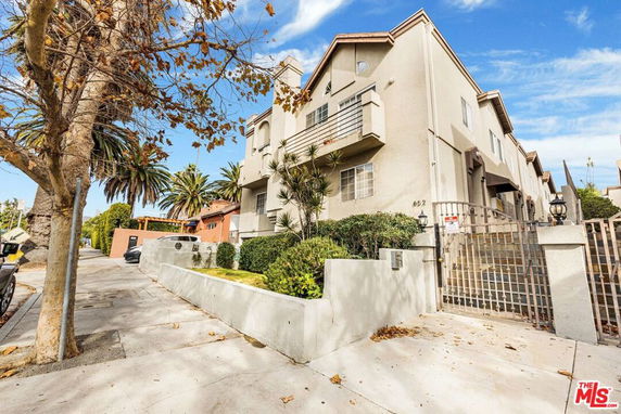 Front view of a multi-story residential building with gated entrance.