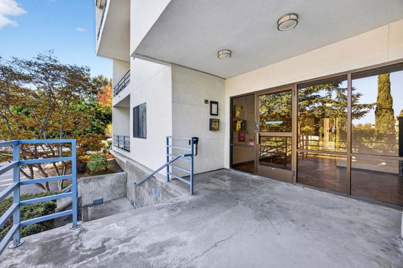 Entrance area of a building with glass doors and concrete flooring.